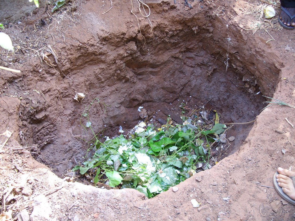 Можно ли закапывать листья. Компостная яма. Компостная яма в земле. Компостная яма вырытая в земле. Заглубленная компостная яма.